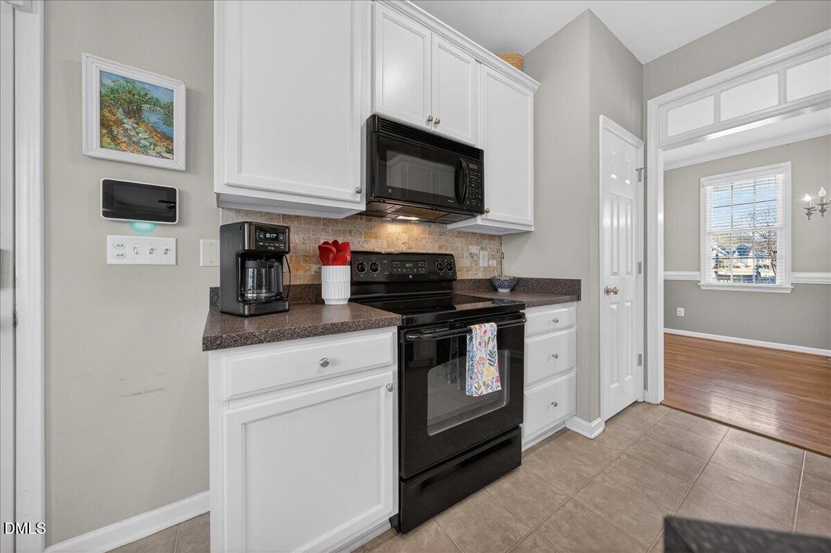 517 Lemon Pepper Place Wendell, NC 27591 - Photo 7 of 19 a kitchen with stainless steel appliances granite countertop white cabinets and black appliances