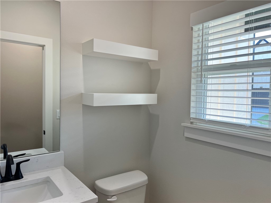 1715 Cuppett Circle Pea Ridge, AR 72751 - Photo 4 of 15 Bathroom featuring a single vanity with a white countertop and rectangular sink, matte black faucet, and a large wall mirror