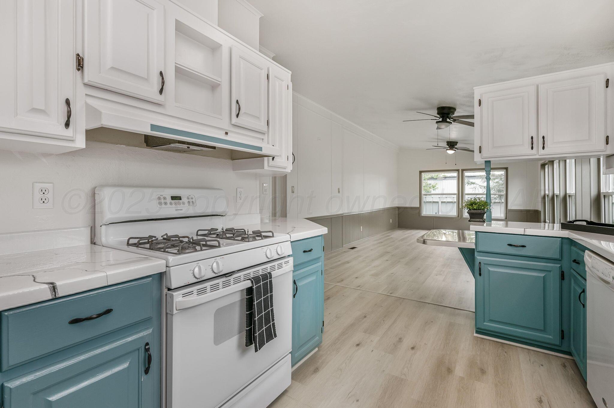 200 5th Avenue Canyon, TX 79015 - Photo 8 of 18 a kitchen with cabinets a stove and a sink