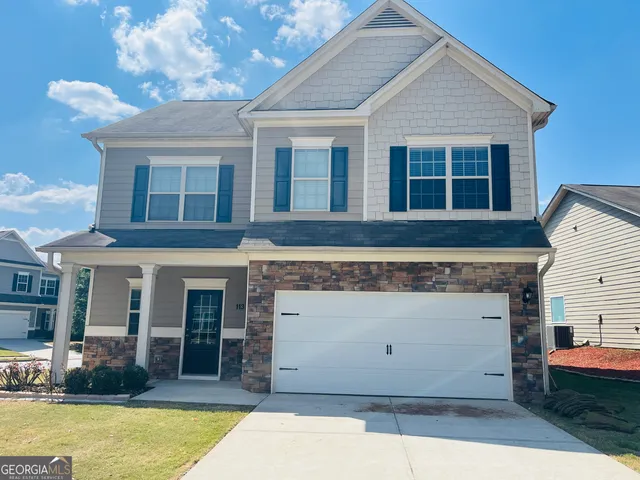 a view of a house with a barbeque and large tree
