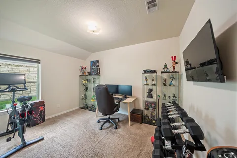 a view of a workspace with furniture and gym equipment
