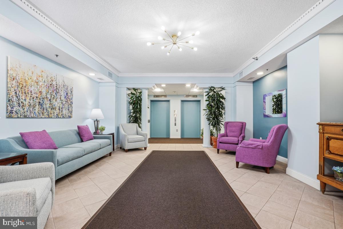 14801 Pennfield Circle, Unit 203 Silver Spring, MD 20906 - Photo 29 of 51 a living room with furniture and a chandelier