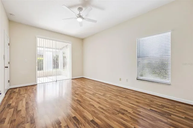a view of an empty room with a window and wooden floor