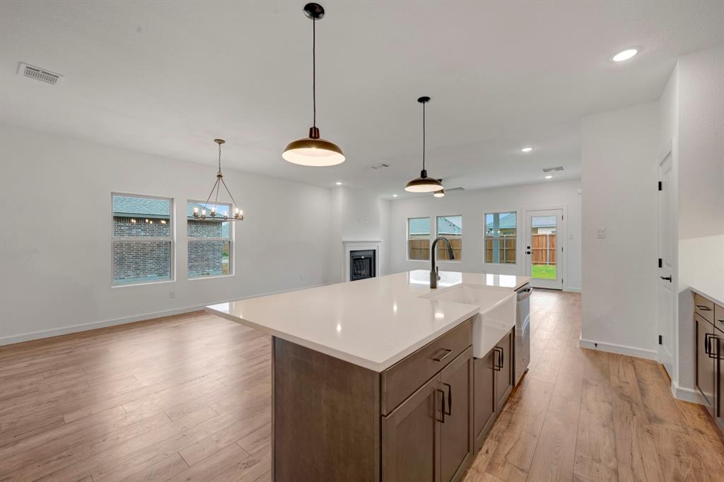 536 Brookside Drive Van Alstyne, TX 75495 - Photo 10 of 30 a kitchen with a sink a chandelier and wooden floor