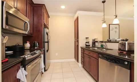 a kitchen with a refrigerator a stove and a sink with wooden floor