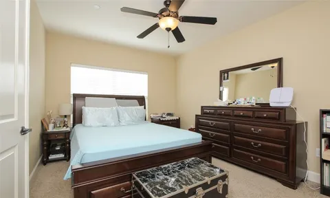 a large bedroom with a bed and a flat screen tv