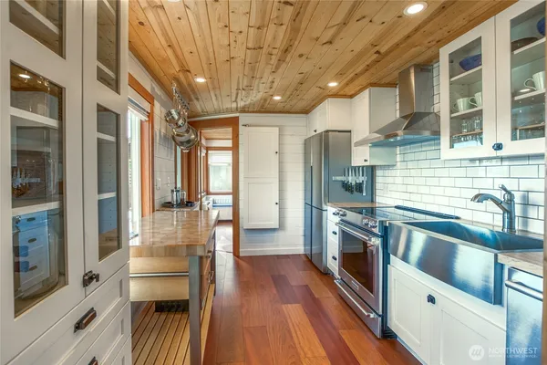 a kitchen with stainless steel appliances granite countertop a refrigerator a stove and a sink