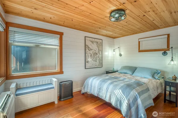 a bedroom with a bed and a painting on the wall