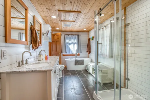 a bathroom with a granite countertop sink a mirror and a shower