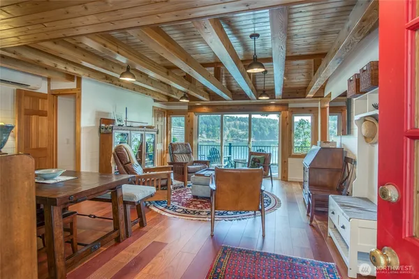 a living room with furniture a large window with wooden floor and furniture