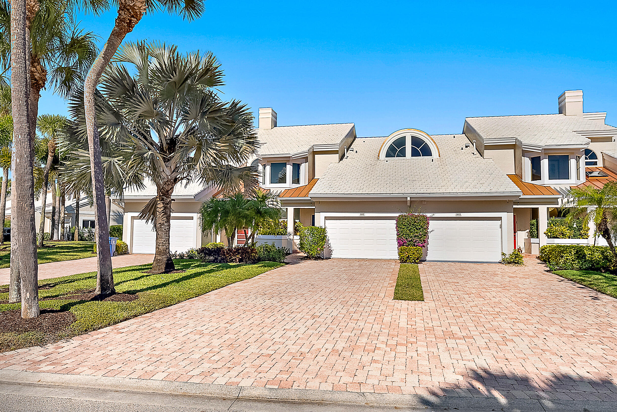 1602 Captains Way Jupiter, FL 33477 - Photo 14 of 36 a front view of a house with a yard and garage