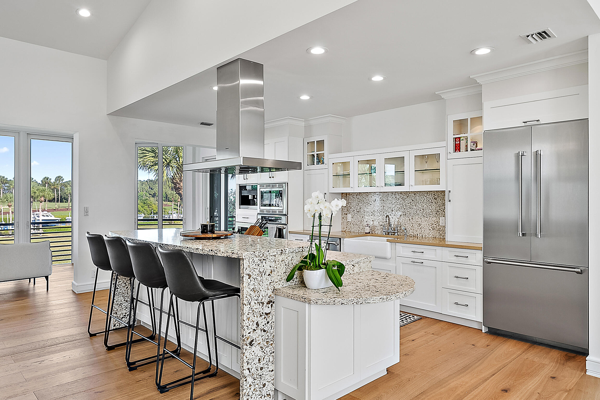 1602 Captains Way Jupiter, FL 33477 - Photo 6 of 36 a kitchen with stainless steel appliances granite countertop a refrigerator a stove and white cabinets with wooden floor