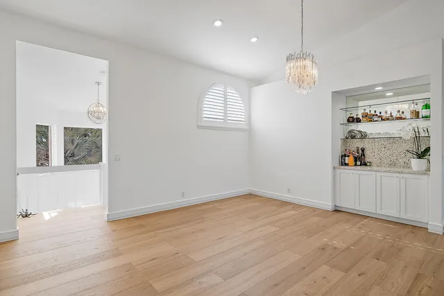 an empty room with wooden floor and window