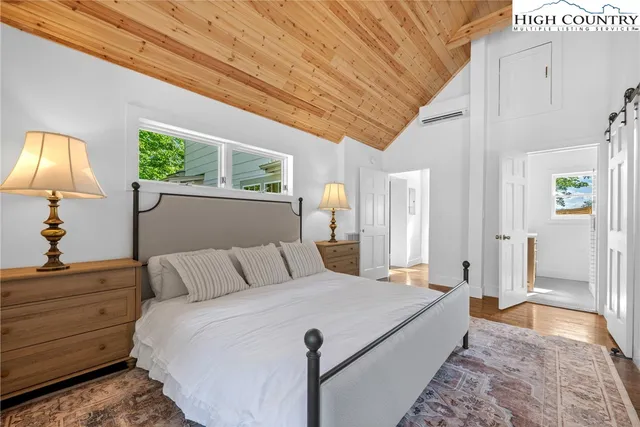 a bedroom with a bed and a lamp on dresser