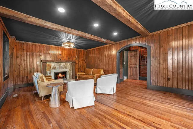 a living room with furniture a fireplace and wooden floor