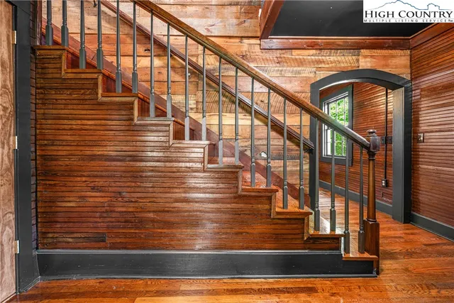 a view of staircase with a rug and wooden floor