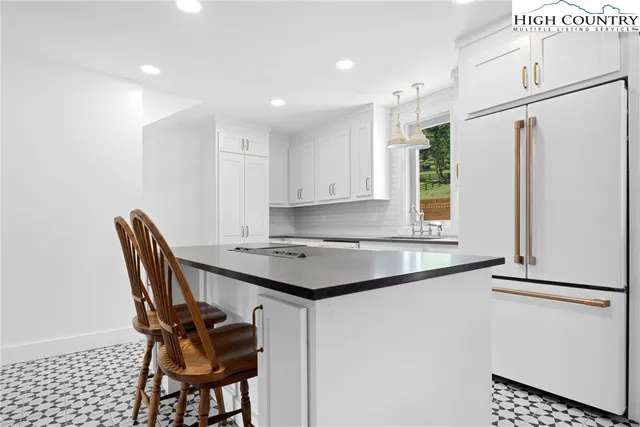 a kitchen with stainless steel appliances granite countertop a refrigerator and a stove top oven