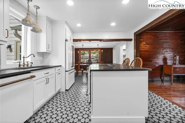 a large kitchen with granite countertop a sink and a refrigerator