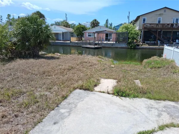 a front view of a house with a yard and a pond