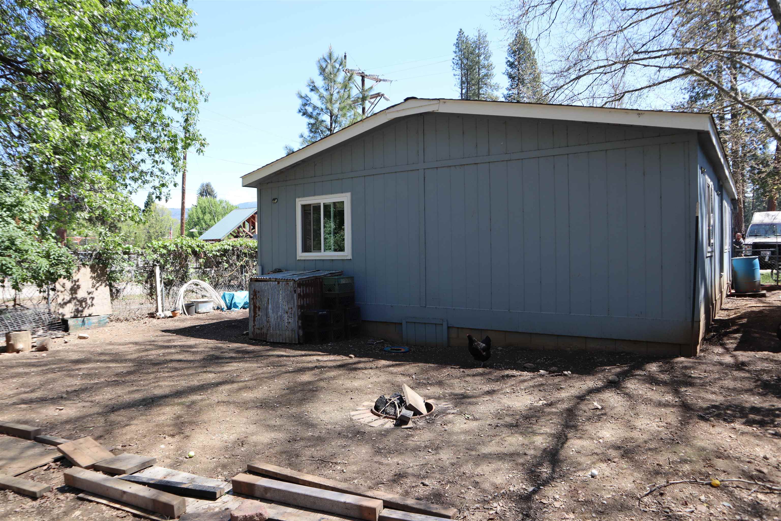 193 Fairground Road Quincy, CA 95971 - Photo 17 of 20 a backyard of a house with wooden fence and large trees