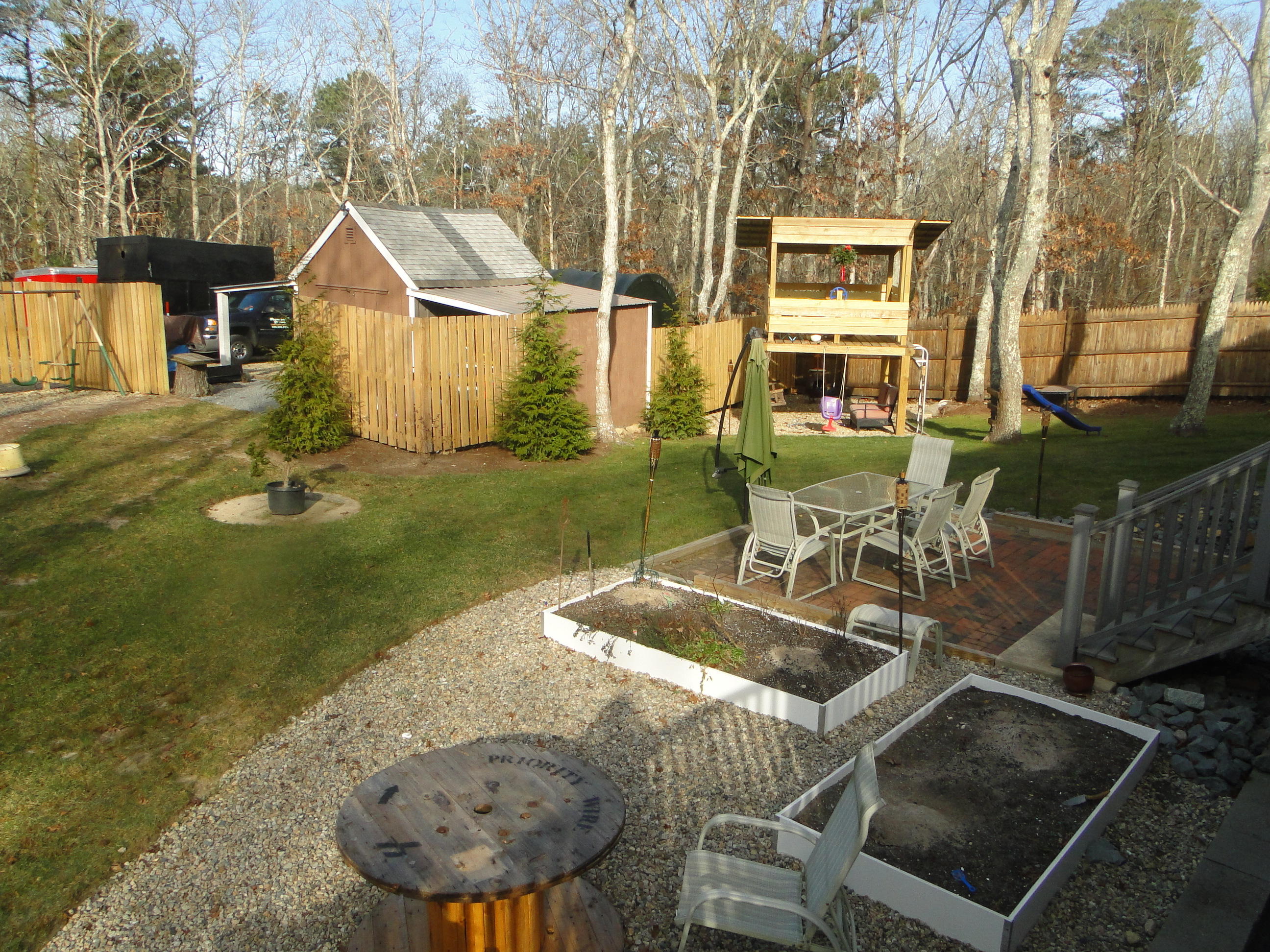 10 Bayview Road East Sandwich, MA 02537 - Photo 16 of 19 a view of a backyard with table and chairs potted plants and large tree