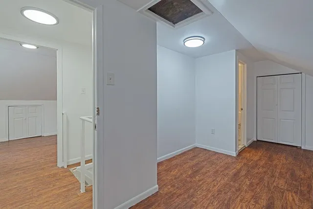 an empty room with wooden floor and entrance