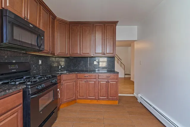 a kitchen with granite countertop a stove a microwave and cabinets