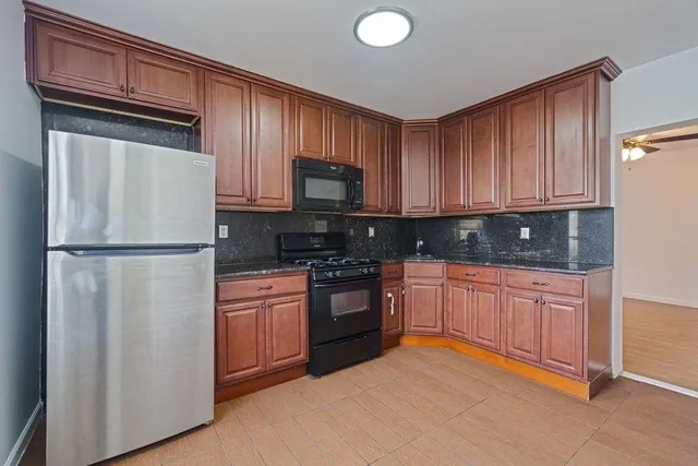 a kitchen with stainless steel appliances granite countertop a refrigerator stove a sink dishwasher and microwave