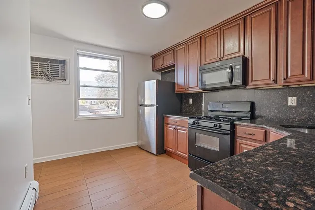 a kitchen with stainless steel appliances granite countertop a stove a sink dishwasher a refrigerator and cabinets with wooden floor