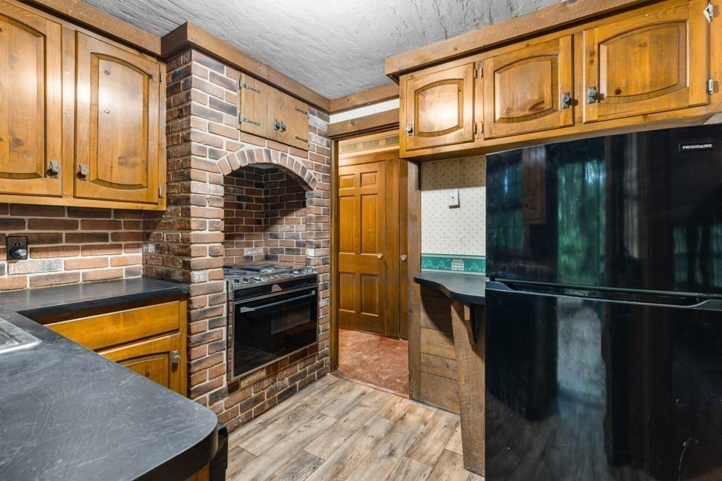 19 Forest Road Wakefield, MA 01880 - Photo 20 of 30 a kitchen with stainless steel appliances granite countertop a refrigerator a stove and a sink with wooden floor