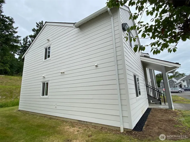 a view of a white house with a yard and potted plants