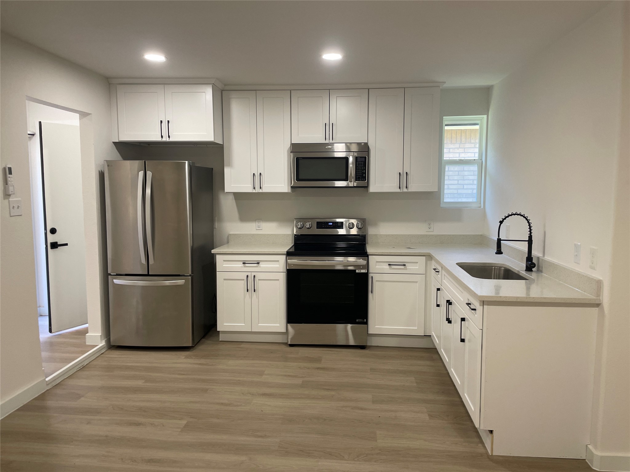 5602 Circlegate Drive, Unit B Spring, TX 77373 - Photo 3 of 8 a kitchen with a sink a refrigerator and a stove