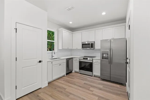 a kitchen with cabinets stainless steel appliances and window