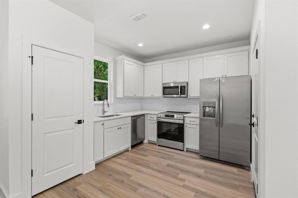 516 Florence Denison, TX 75020 - Photo 11 of 27 a kitchen with cabinets stainless steel appliances and window