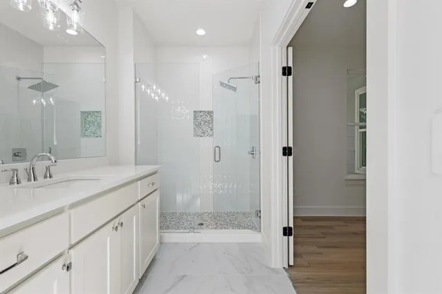 a bathroom with a granite countertop sink mirror and shower