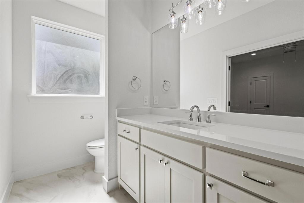 516 Florence Denison, TX 75020 - Photo 18 of 27 a bathroom with a granite countertop sink a toilet and a mirror