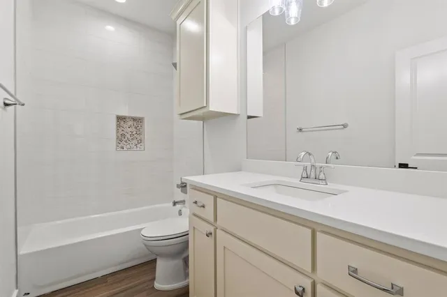 a bathroom with a granite countertop toilet a sink and a bathtub