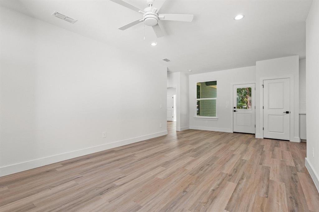 516 Florence Denison, TX 75020 - Photo 6 of 27 an empty room with wooden floor chandelier fan and windows