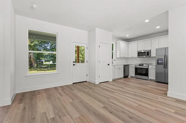 a view of kitchen with wooden floor electronic appliances and window