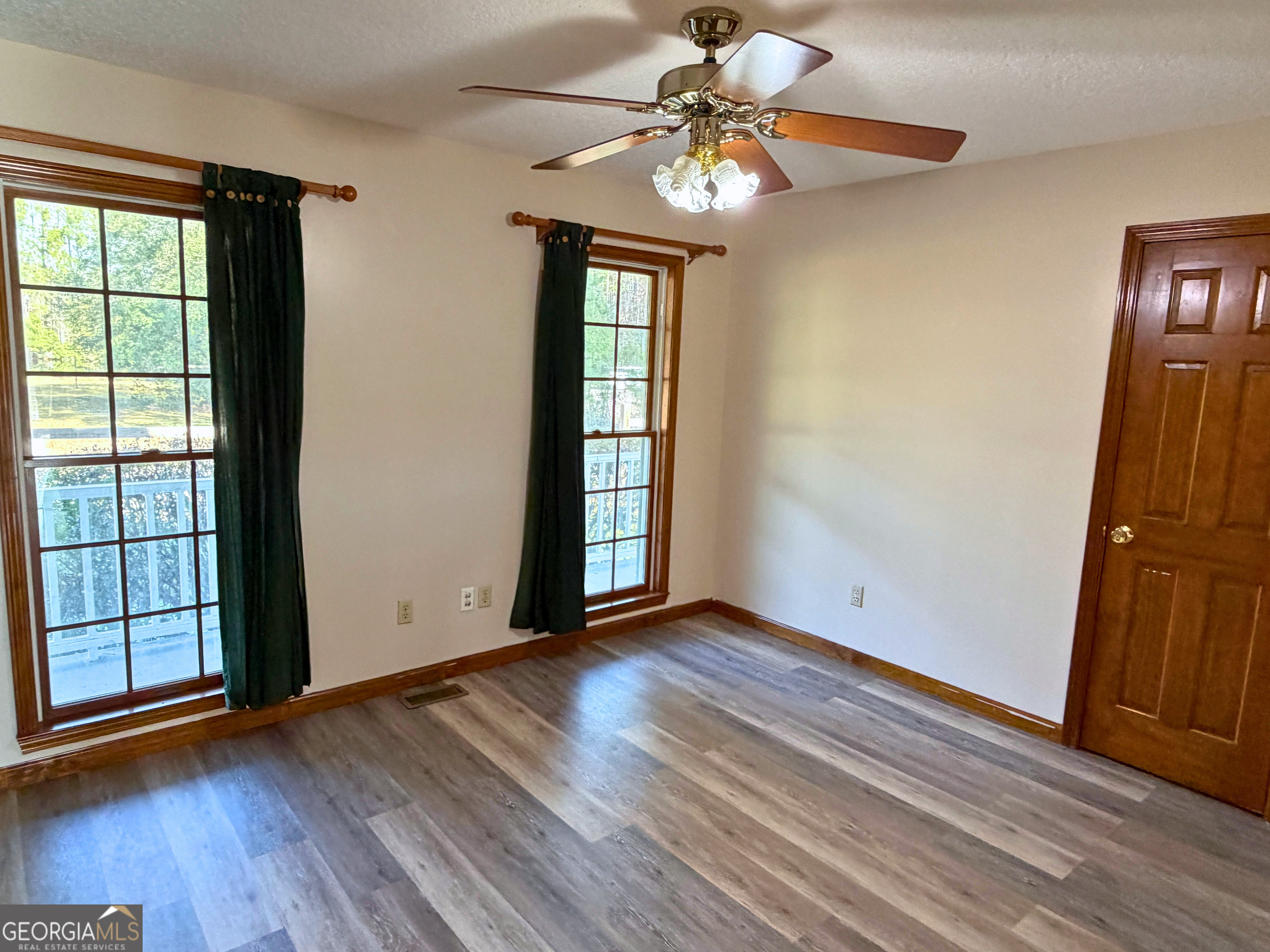 1818 Union Carbide Road Woodbine, GA 31569 - Photo 20 of 33 an empty room with wooden floor fan and windows