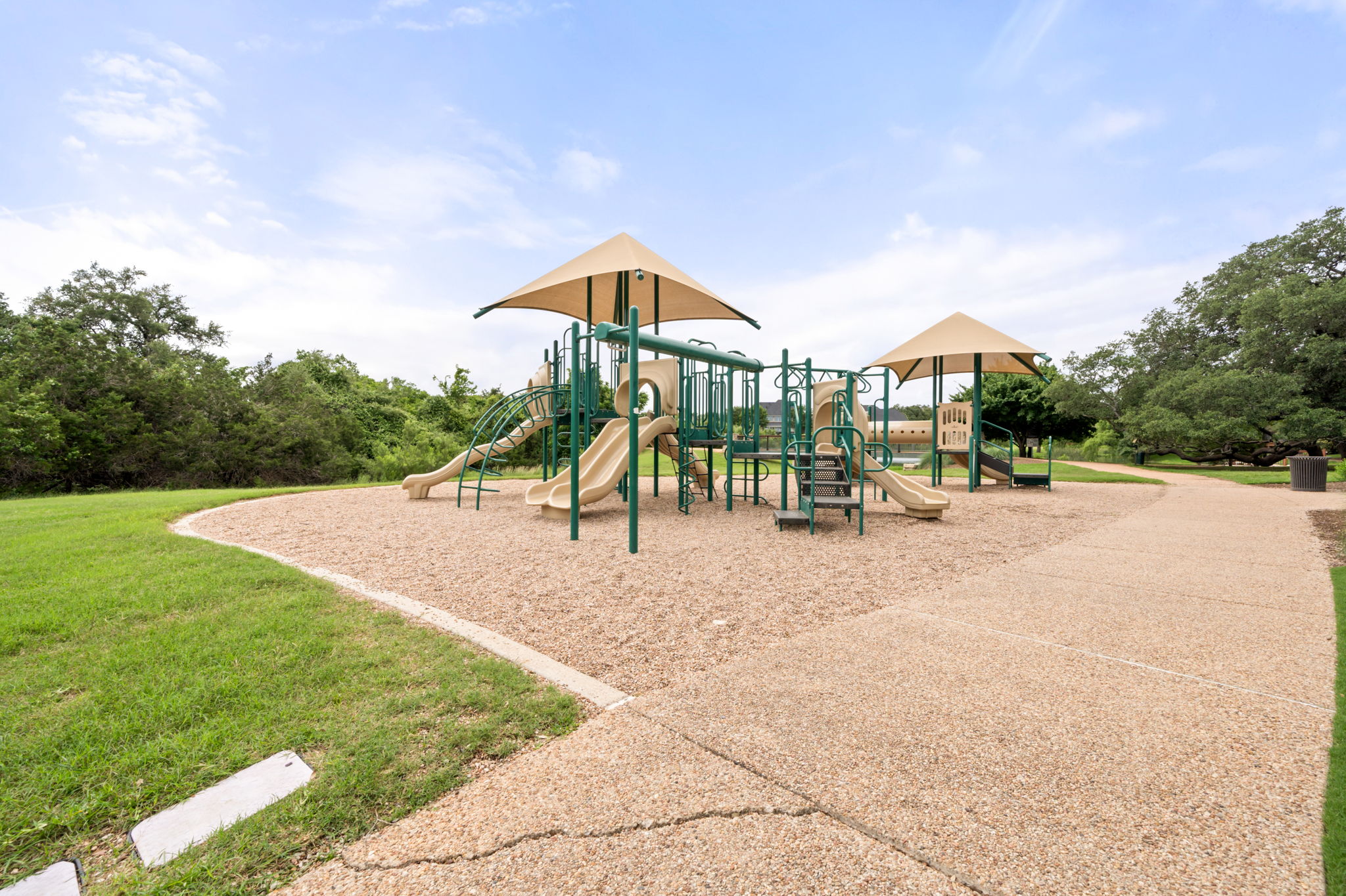 1581 Grassy Field Road Austin, TX 78737 - Photo 37 of 37 A well-maintained community park borders a paved walking path under mature shade trees.