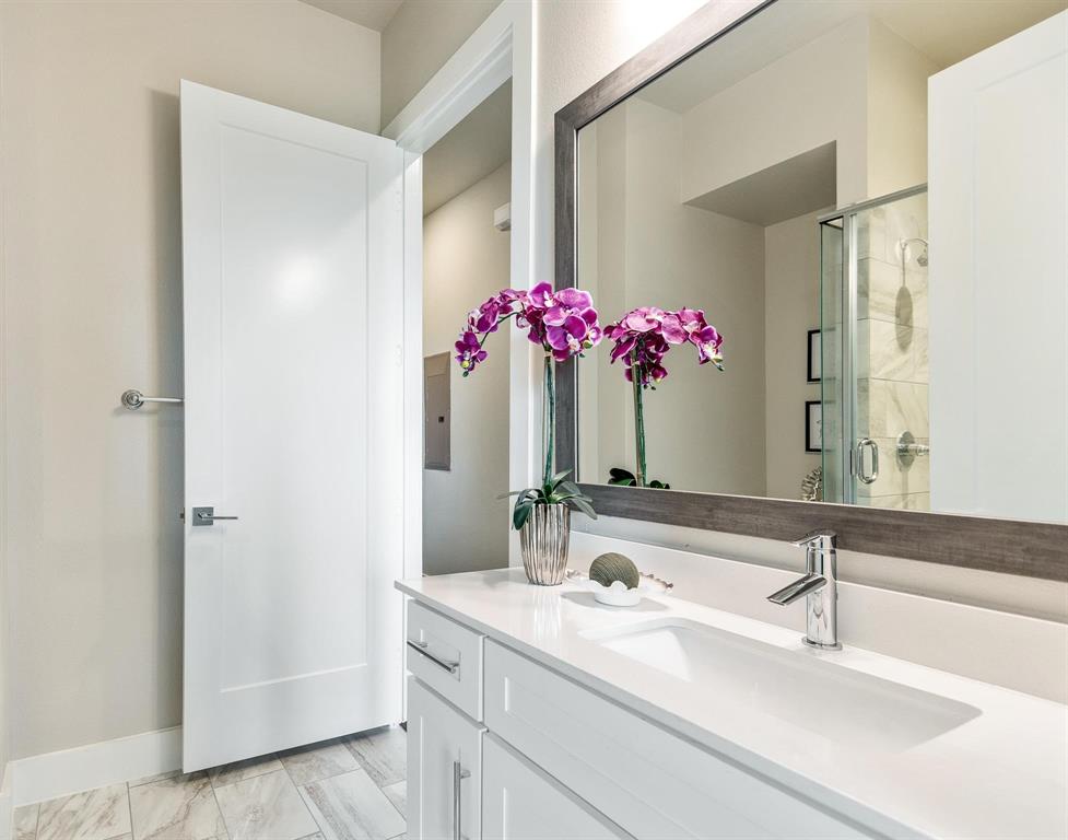 770 North Plano Road, Unit 303 Richardson, TX 75081 - Photo 17 of 25 Bathroom featuring a vanity with a white countertop and an integrated sink, a large mirror with a wooden frame, and a shower with a clear glass enclosure