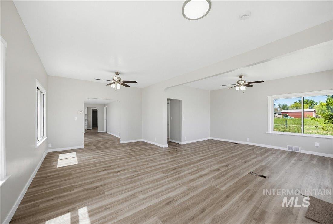 30013 Apple Valley Road Parma, ID 83660 - Photo 6 of 25 Spacious room featuring wood-finish flooring, light grey walls, and white trim