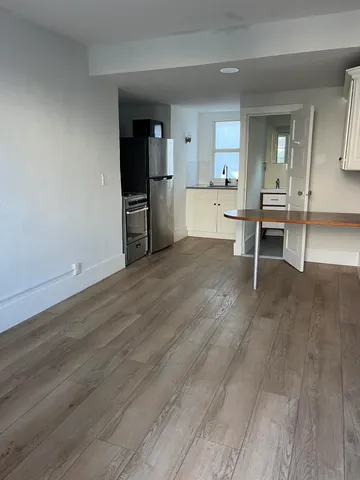 a view of a kitchen with wooden floor and a sink
