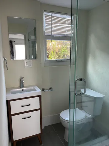 a bathroom with a toilet a sink and mirror