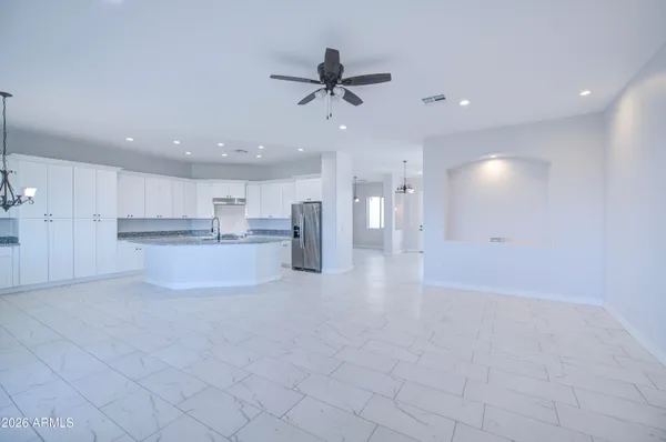a kitchen with stainless steel appliances granite countertop a refrigerator sink and white cabinets