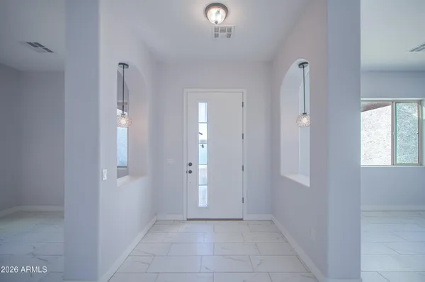 an empty room with windows and fan