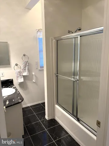 a bathroom with a glass shower door and a sink