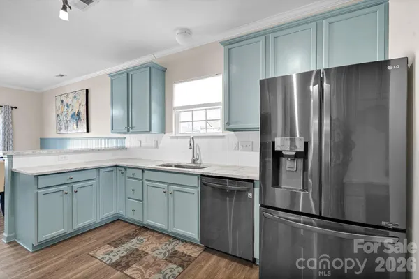 a kitchen with stainless steel appliances granite countertop a refrigerator and a sink