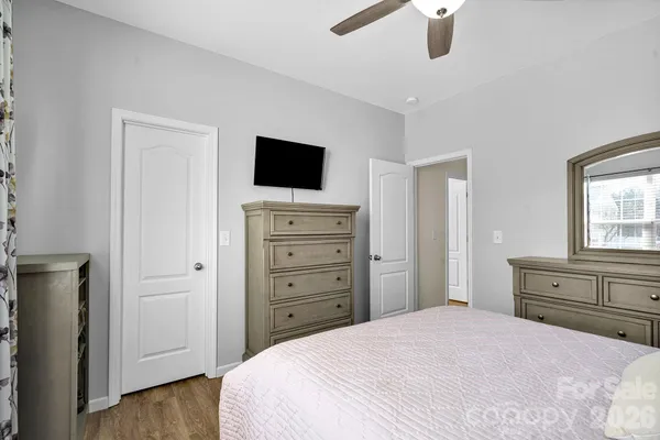 a bedroom with a bed and a flat tv screen on dresser